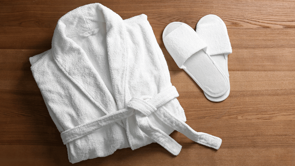 Femme pliant un peignoir éponge blanc avec la technique du rectangle